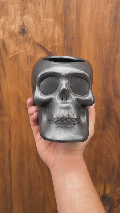 Maceta de arcilla negra con forma de calavera